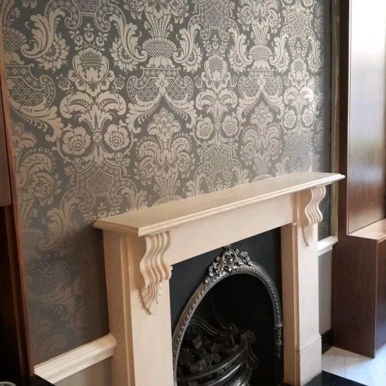 Ornate damask wallpaper with Victorian fireplace