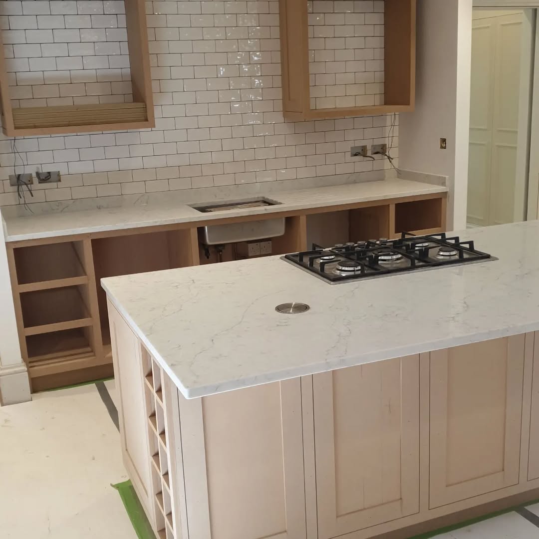 Kitchen before — bare unpainted cabinets